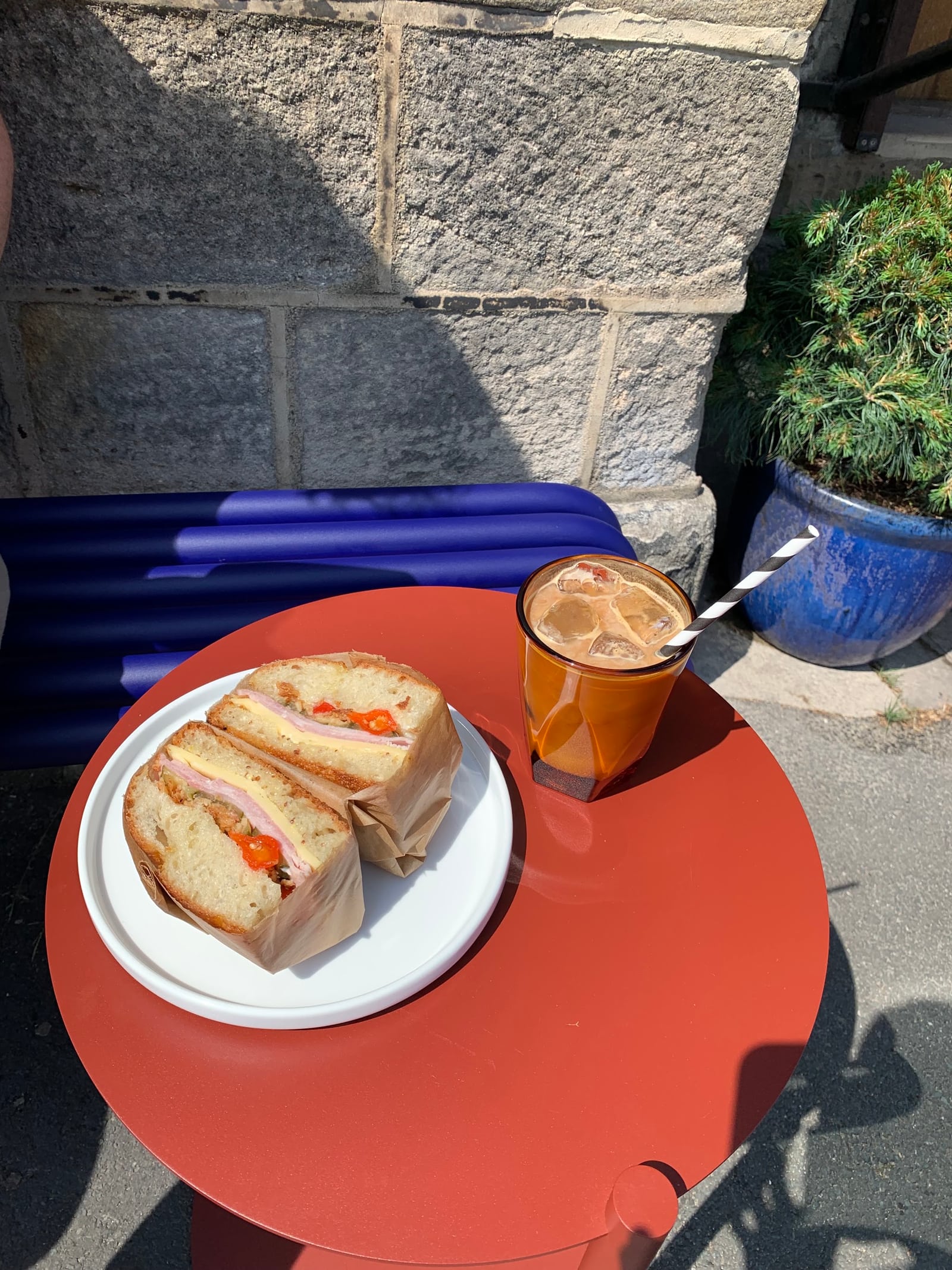 An iced coffee and focaccia on one of the outdoor tables